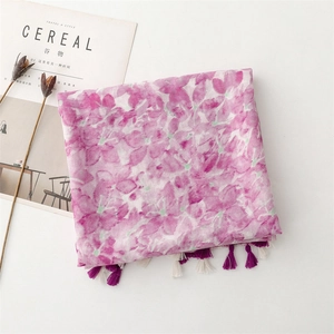 Detail of pink floral scarf with elegant fringe tassels and decorative magazine accent