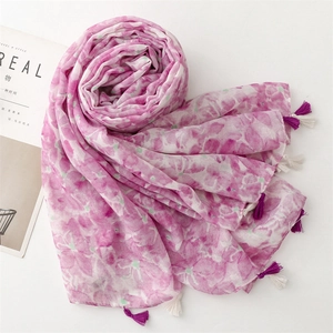 Detailed macro shot of floral print scarf with elegant purple and white fringe tassels