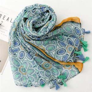 Detailed view of bohemian silk scarf with ethnic geometric patterns and colorful tassels