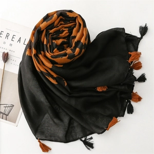 Detail of leopard print scarf with fringe tassels on minimalist magazine background