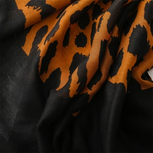 Macro shot of twill leopard print scarf fabric showing soft texture and orange-black pattern