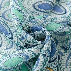 Close-up of lightweight paisley fabric showing blue-green patterns and soft texture