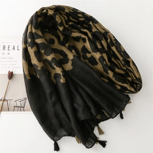 Detail of leopard print scarf with black and brown tassels on white background