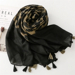 Detailed macro view of stylish leopard print scarf with soft tassels and woven texture