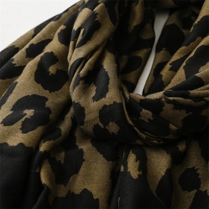 Detailed close-up of soft cotton-linen texture on leopard print scarf with fringe edge