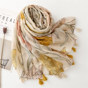 Close-up of lightweight yellow cotton scarf featuring floral print and bicolor fringe details