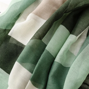 Close-up of lightweight green geometric check scarf showing cotton linen fabric texture
