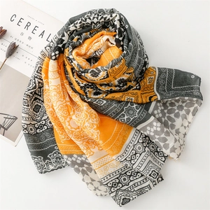 Detail of bohemian orange and grey shawl with geometric patterns and floral motifs