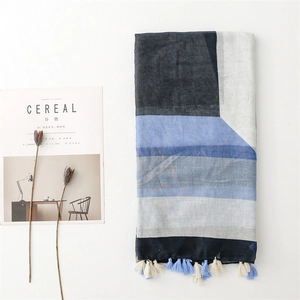 Detail of color-block geometric cotton scarf with tassels and minimalist aesthetic setup