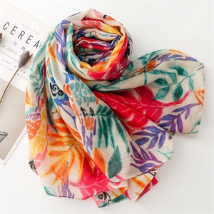 Detail of soft linen-feel scarf with tropical parrot leaf print and vibrant colors