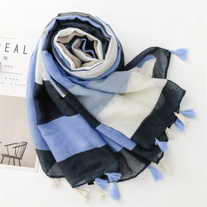 Detailed view of striped cotton-linen scarf texture with blue and beige tassel fringe