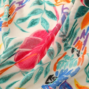 Detail of soft linen-feel scarf showing colorful parrot and leaf prints on thin fabric
