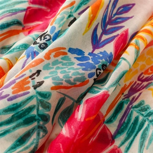 Macro detail of tropical leaf print on soft cotton-linen scarf fabric with vibrant colors