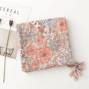 Detailed view of floral cotton scarf with silver silk thread and fringe tassels