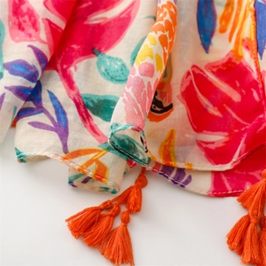 Detail of lightweight scarf featuring tropical parrot print and orange tassels