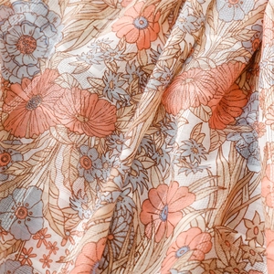 Detailed view of floral printed scarf fabric with subtle silver thread and soft texture