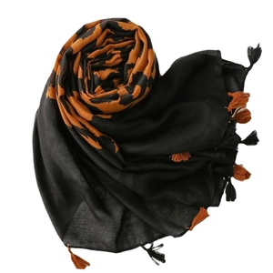 Black and orange leopard print scarf with fringe tassels in a stylish spiral arrangement