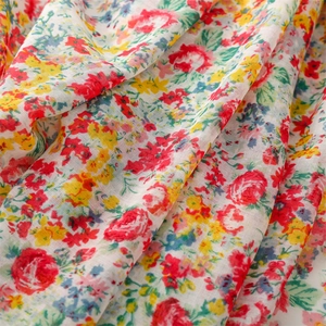Detailed macro view of soft cotton-blend floral fabric with delicate tassels and roses