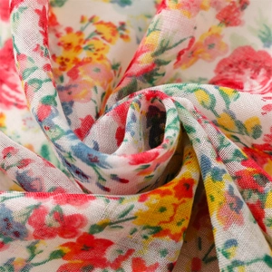 Macro shot of floral print fabric with red, yellow, and blue flowers on soft linen-feel scarf