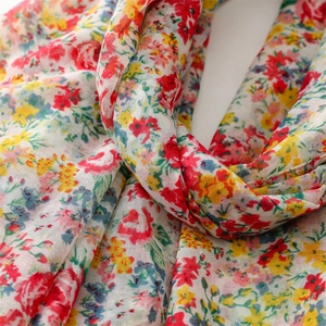 Close-up of lightweight floral scarf showing soft cotton-linen texture and vibrant prints