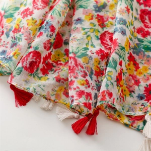 Close-up of floral print cotton scarf with colorful flowers and fringed tassels