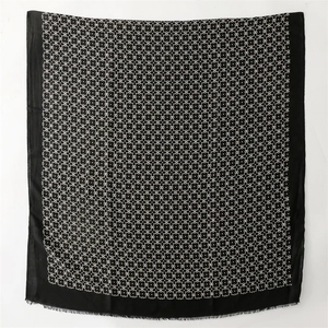 Detail of geometric pattern on woven scarf with delicate black fringe edges