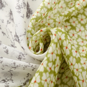 Close-up of lightweight floral cotton scarf fabric with detailed grey and green prints