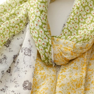 Close-up of floral patchwork scarf with green clover and yellow vintage flower patterns