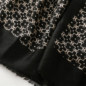 Macro shot of cotton blend scarf showing soft texture and geometric floral pattern with fringe