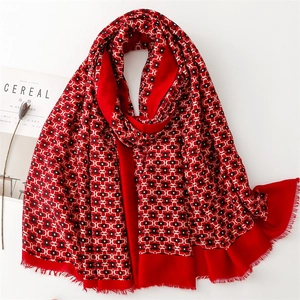 Detail of red geometric pattern cotton scarf with fringe on a minimalist background
