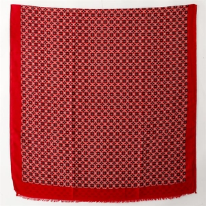 Macro view of red scarf featuring black and white geometric patterns and fringed edges