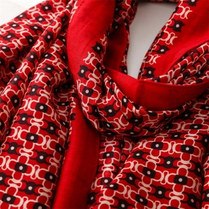 Detailed macro view of geometric chain print on soft red cotton-feel scarf fabric