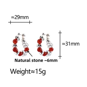 Detail view of C-shaped earrings with red natural stone beads and silver components