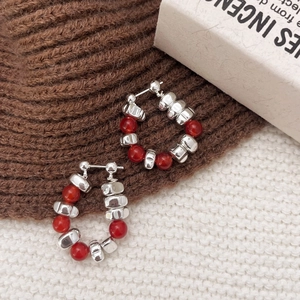 Tiger eye and red agate beaded hoop earrings on cozy autumn knit background