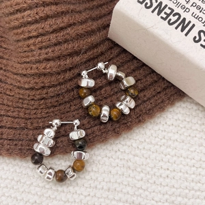 Tiger eye stone and silver bead hoop earrings on white and brown knit fabric