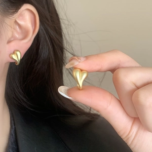 Elegant matte gold heart-shaped stud earrings shown on model for a minimalist vintage look