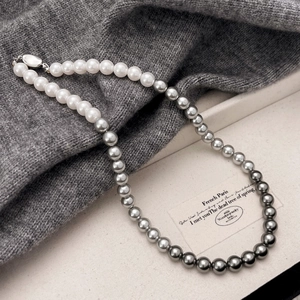 Elegant gradient pearl necklace featuring white to dark grey transitions with metal clasp