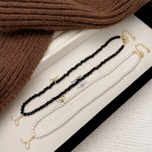 Elegant pearl and black beaded necklaces with shimmering cubic zirconia fishtail pendants