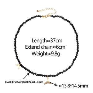 Detail of beaded necklace with black crystal pearls and golden fish tail pendant
