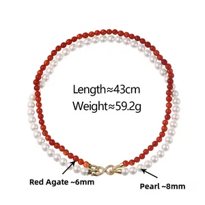 Detail of double-layer necklace with red agate beads, pearls and gold infinity clasp
