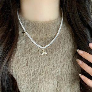 Elegant pearl necklace featuring double mermaid tail pendants with micro-pave zircons