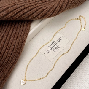 Collier pendentif cœur doré avec nacre et zircon présenté dans son écrin à bijoux