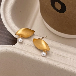 Golden brushed metal leaf earrings with round white pearls in a minimalist geometric design