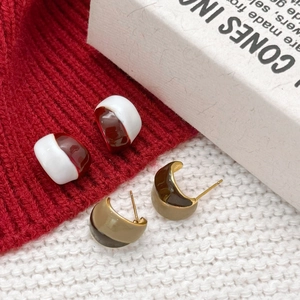 Retro red and white enamel gold-plated earrings on soft knit texture for winter style