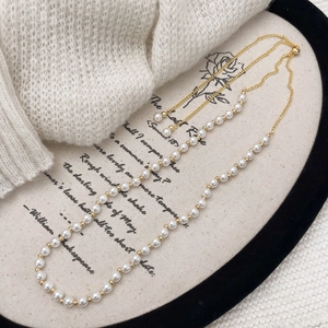 Close-up of pearl necklace with gold chain and adjustable slider clasp on elegant tray