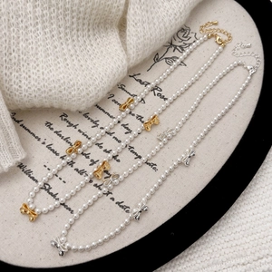 Set di collane di perle con fiocchi metallici su un vassoio decorativo in stile vintage