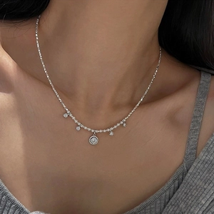Detailed view of silver-toned pearl choker with pave-set diamond pendant on model neck