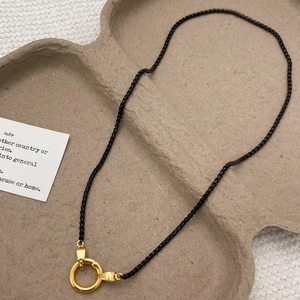Detail of 18k gold plated round spring clasp on a black matte box chain necklace