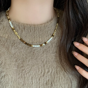 Retro Tiger Eye beaded necklace with pearls on a model wearing a brown sweater