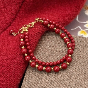 Bracelet double couche en perles rouges avec perles dorées sur fond en maille hivernale